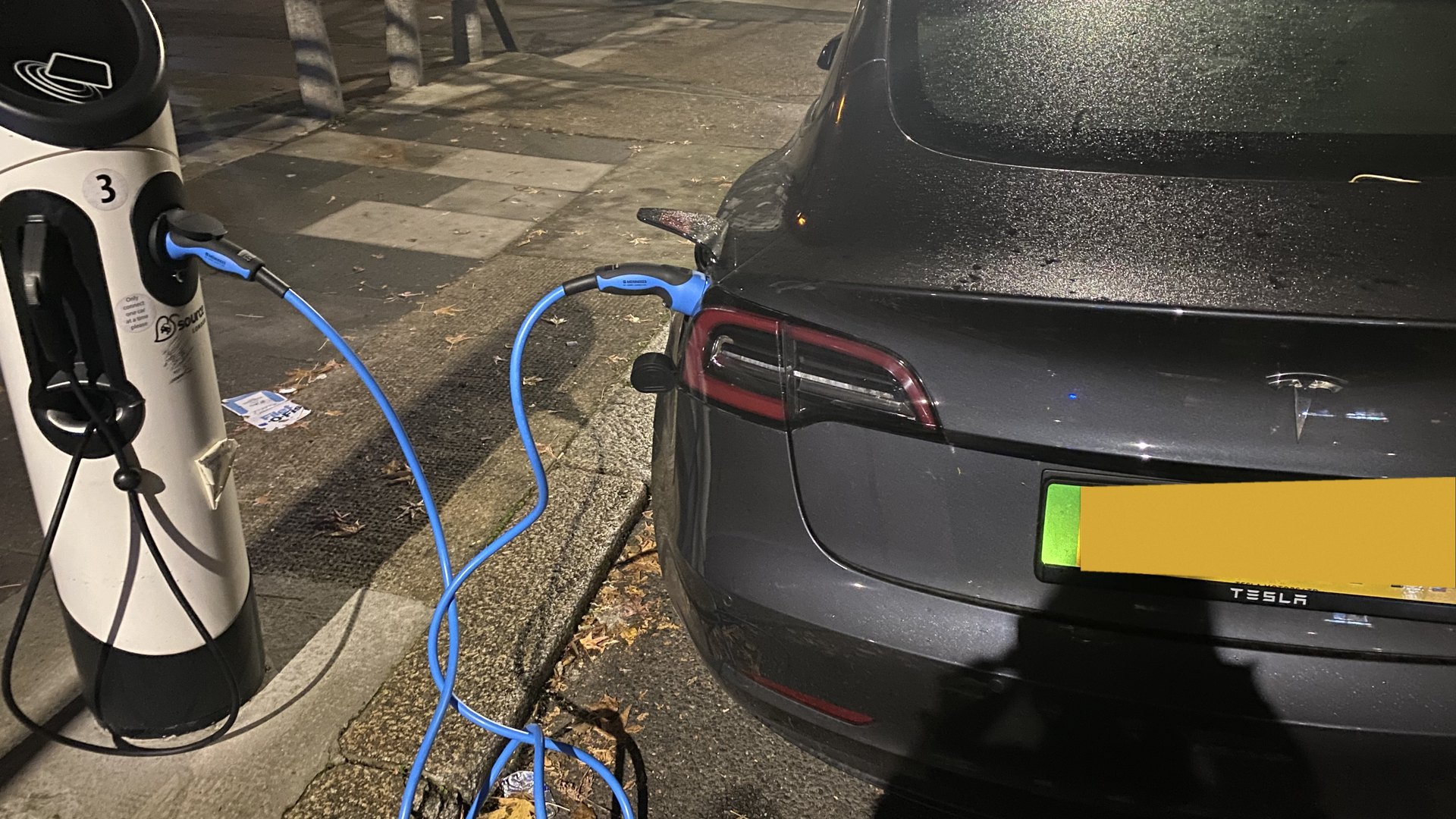 路肩の充電ポストにつながれたEV